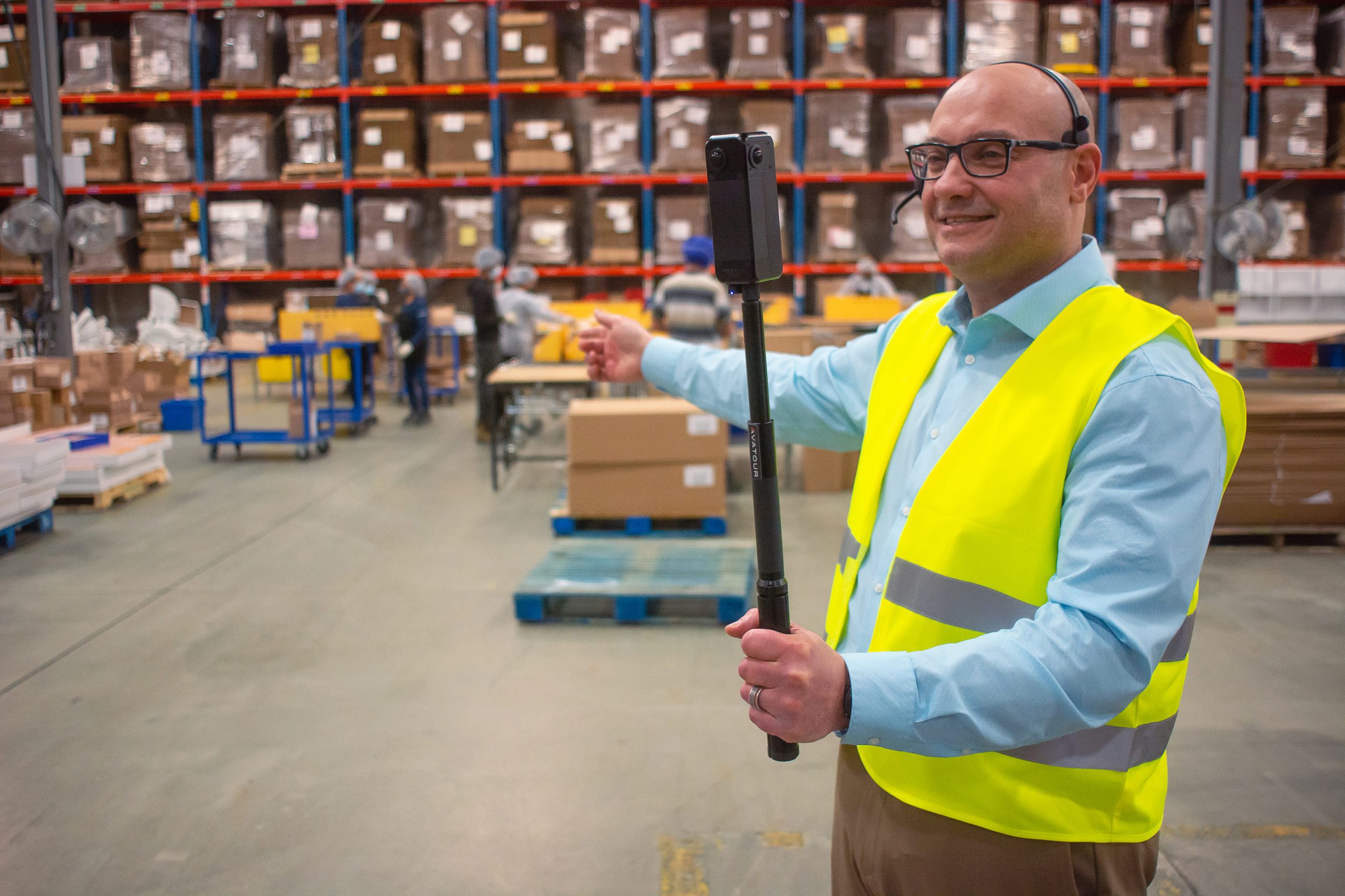 camera operator holding 360 degree camera in warehouse